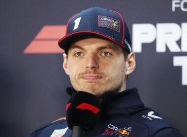 a man with a cap on and microphone in front of him